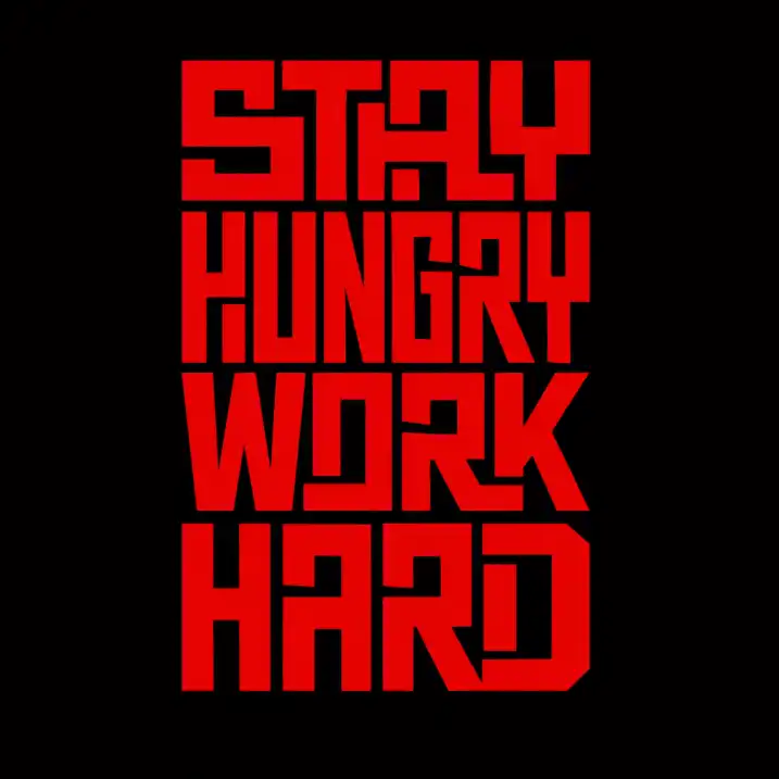 Create a bold condensed block typography t-shirt design featuring a strong motivational phrase such as "STAY HUNGRY WORK HARD." Arrange the words in a tightly stacked vertical layout that forms a compact rectangular shape. Use a custom tall geometric font with sharp corners, thick uniform strokes, and maze-like internal line construction so the letters feel interconnected and architectural. Keep spacing extremely tight so the composition appears solid and monolithic. Use a vivid red color for all lettering against a solid black background to create high contrast and dramatic impact. Maintain clean edges with a flat vector style and no gradients or shadows for a powerful minimalist streetwear aesthetic. Use aspect ratio 1:1.