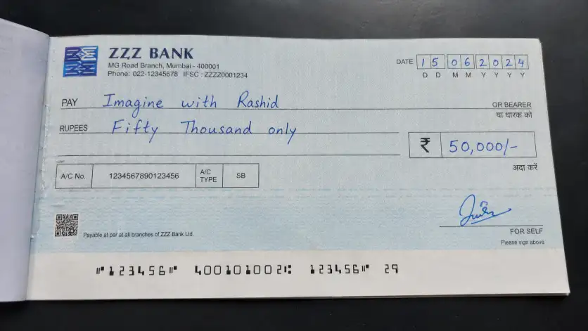 Create a realistic close-up photo of an Indian bank cheque from ZZZ Bank placed on a dark surface, filled out by hand with blue ink, payable to "Imagine with Rashid", with a date, with the amount written as "Fifty Thousand only" and ₹50,000 clearly written in the amount box, featuring printed details like IFSC code, account number, branch address, subtle paper texture, security patterns, slight shadows, and natural lighting for a genuine look, aspect ratio 16:9.