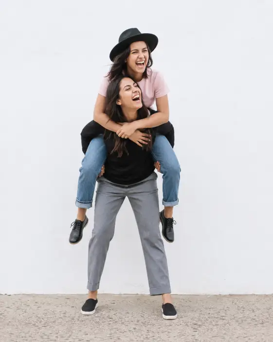 Piggyback Laugh Against a White Wall